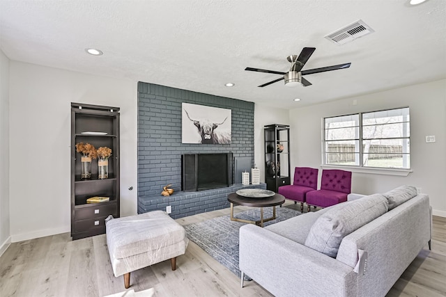 1201 Shady Oak Ln, Dickinson, TX 77539 - living room featuring ceiling fan, wood finished floors, a brick fireplace, recessed lighting, and a textured ceiling