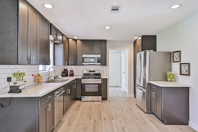 1201 Shady Oak Ln, Dickinson, TX 77539 - kitchen with stainless steel appliances, light wood-style flooring, tasteful backsplash, light countertops, and recessed lighting
