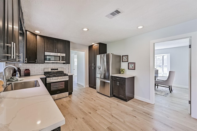 1201 Shady Oak Ln, Dickinson, TX 77539 - kitchen featuring stainless steel appliances, decorative backsplash, light wood finished floors, dark brown cabinets, and recessed lighting