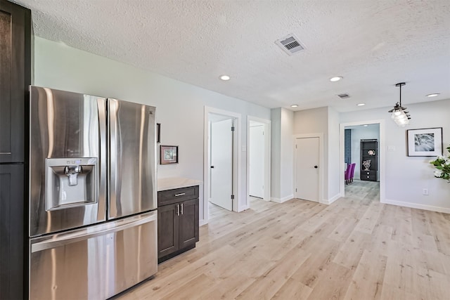 1201 Shady Oak Ln, Dickinson, TX 77539 - kitchen featuring stainless steel fridge with ice dispenser, light wood-style floors, a textured ceiling, light countertops, and recessed lighting