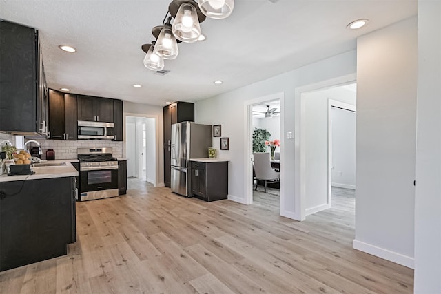 1201 Shady Oak Ln, Dickinson, TX 77539 - kitchen with appliances with stainless steel finishes, light countertops, light wood-type flooring, decorative backsplash, and recessed lighting