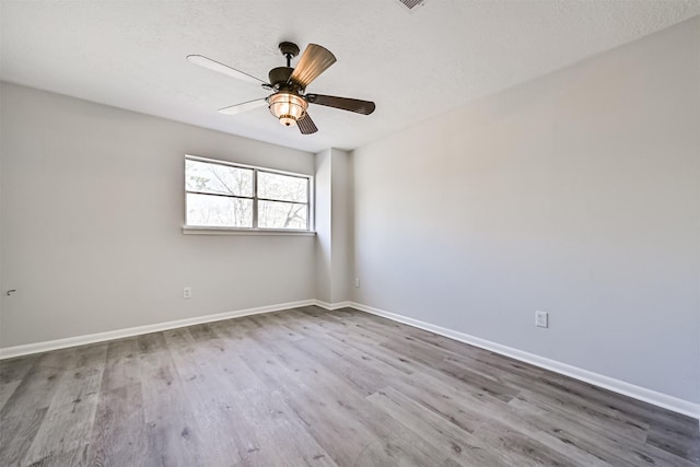 1201 Shady Oak Ln, Dickinson, TX 77539 - empty room with wood finished floors, a ceiling fan, and a textured ceiling