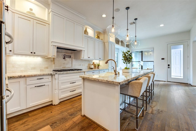 1403 Wakefield Dr, Houston, TX 77018 - kitchen with recessed lighting, backsplash, dark wood finished floors, white cabinets, and light stone countertops