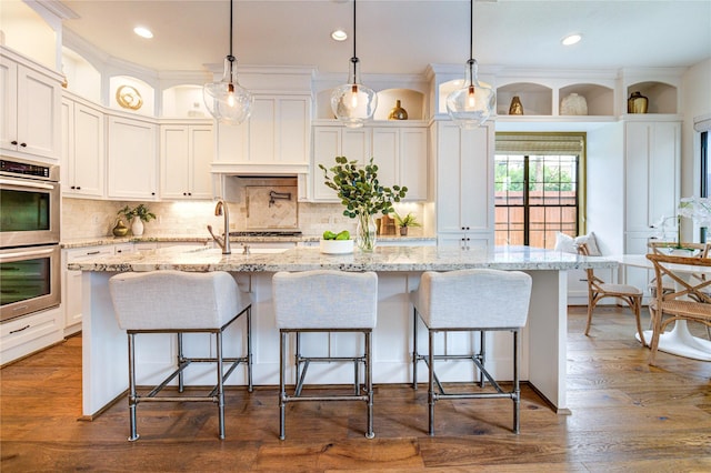 1403 Wakefield Dr, Houston, TX 77018 - kitchen with double oven, white cabinetry, backsplash, a large island, and a kitchen breakfast bar
