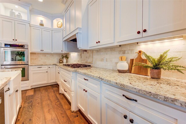 1403 Wakefield Dr, Houston, TX 77018 - kitchen featuring stainless steel appliances, white cabinetry, wood finished floors, and glass insert cabinets