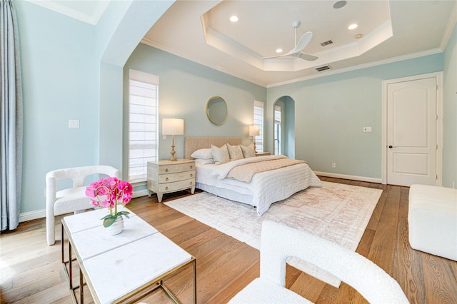 1403 Wakefield Dr, Houston, TX 77018 - bedroom with arched walkways, a tray ceiling, ornamental molding, recessed lighting, and light wood-style flooring