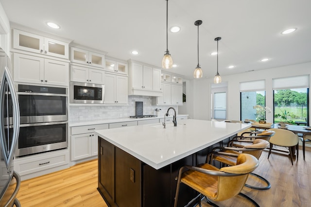 6618 Mirabeau Ln, Katy, TX 77493 - kitchen featuring appliances with stainless steel finishes, light wood-type flooring, light countertops, tasteful backsplash, and recessed lighting
