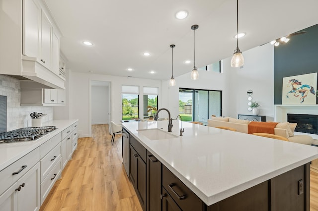 6618 Mirabeau Ln, Katy, TX 77493 - kitchen with stainless steel gas stovetop, light wood finished floors, white cabinets, light countertops, and recessed lighting