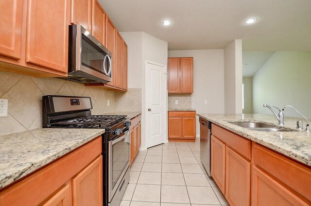 24938 Pavarotti Pl, Katy, TX 77493 - kitchen with appliances with stainless steel finishes, light tile patterned flooring, light stone counters, backsplash, and recessed lighting