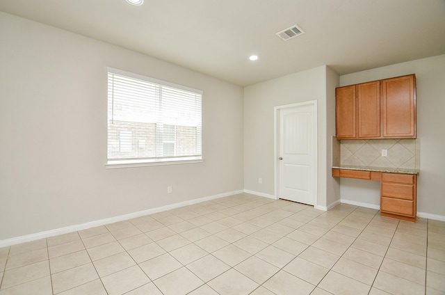 24938 Pavarotti Pl, Katy, TX 77493 - kitchen with built in study area, backsplash, light tile patterned floors, recessed lighting, and brown cabinets