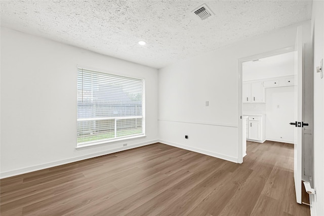 711 Charidges Dr, Houston, TX 77034 - spare room featuring a textured ceiling, wood finished floors, and recessed lighting