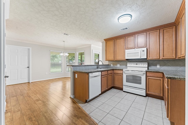 14607 Dawn Mist Ct, Magnolia, TX 77354 - kitchen with white appliances, a peninsula, brown cabinets, ornamental molding, and a textured ceiling