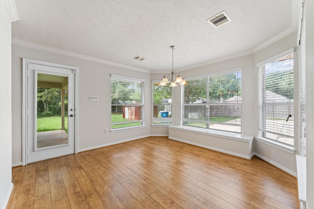 14607 Dawn Mist Ct, Magnolia, TX 77354 - unfurnished dining area featuring a chandelier, a textured ceiling, light wood-type flooring, and crown molding