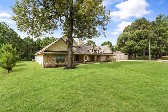 14607 Dawn Mist Ct, Magnolia, TX 77354 - view of front of home featuring a front yard, stone siding, and a chimney