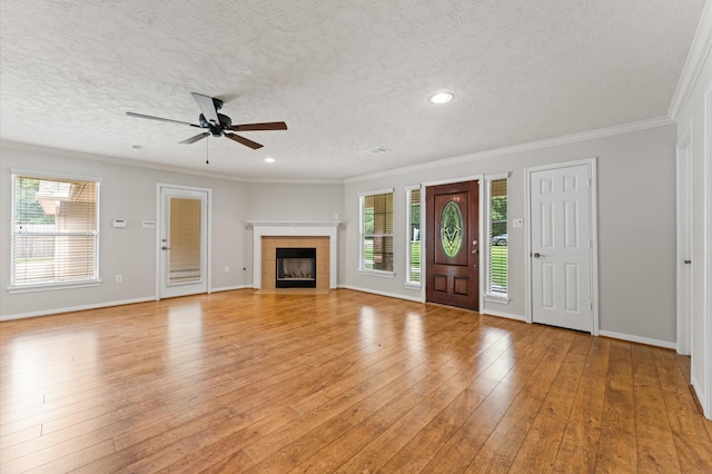 14607 Dawn Mist Ct, Magnolia, TX 77354 - unfurnished living room with ceiling fan, healthy amount of natural light, a textured ceiling, ornamental molding, and light wood finished floors