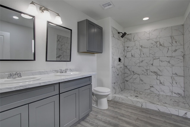 5774 Gineridge Dr, Houston, TX 77053 - bathroom featuring double vanity, tiled shower, wood finished floors, and recessed lighting