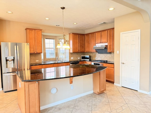 2214 Jurgensen Ln, Sugar Land, TX 77479 - kitchen with stainless steel appliances, under cabinet range hood, a kitchen island, decorative backsplash, and dark stone countertops