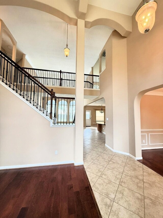 2214 Jurgensen Ln, Sugar Land, TX 77479 - entrance foyer featuring arched walkways, a towering ceiling, wood finished floors, and stairway