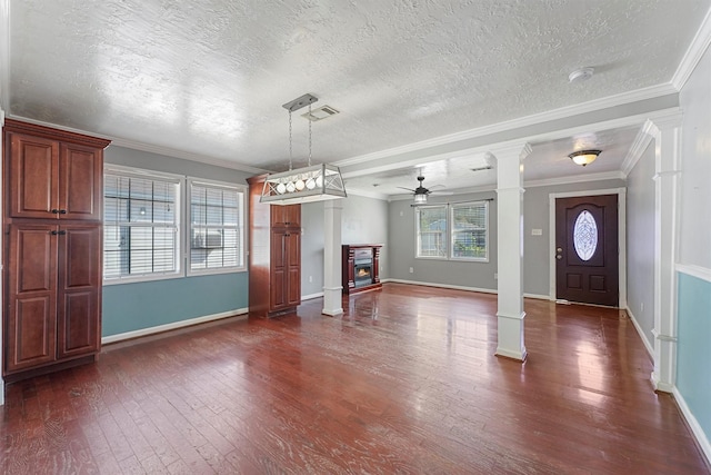 4515 Salina St, Houston, TX 77026 - unfurnished living room with ornate columns, ceiling fan, dark wood-type flooring, a glass covered fireplace, and a textured ceiling
