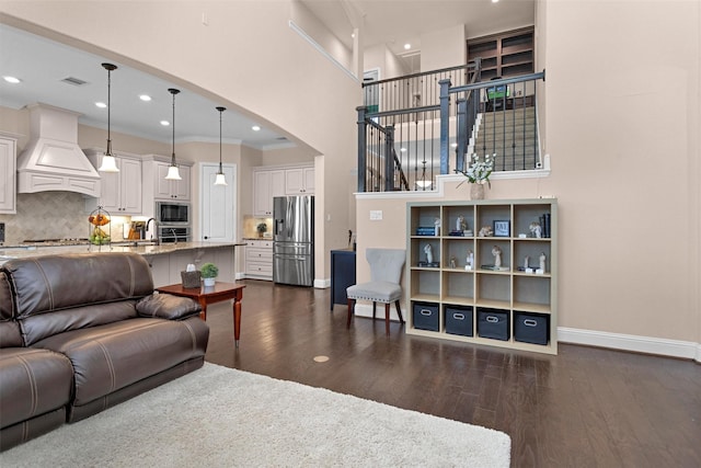 31304 New Forest Park Ln, Spring, TX 77386 - living room featuring crown molding, dark wood-type flooring, recessed lighting, a high ceiling, and arched walkways