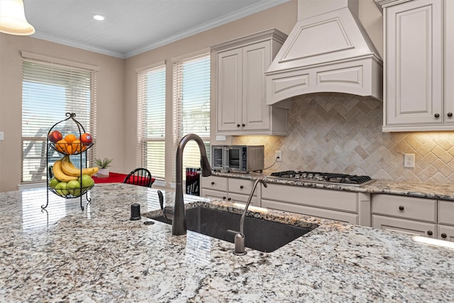 31304 New Forest Park Ln, Spring, TX 77386 - kitchen with light stone countertops, healthy amount of natural light, premium range hood, backsplash, and ornamental molding