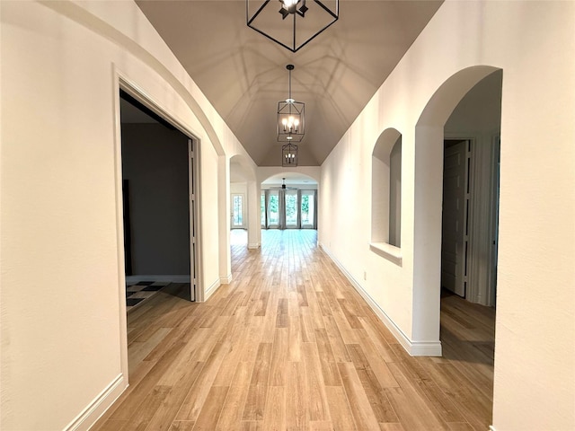 9402 Orchard Trl, Missouri City, TX 77459 - hall featuring light wood finished floors, arched walkways, and a chandelier