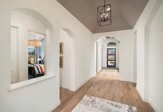 9402 Orchard Trl, Missouri City, TX 77459 - corridor with wood finished floors, a chandelier, high vaulted ceiling, and arched walkways