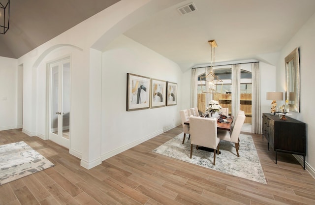 9402 Orchard Trl, Missouri City, TX 77459 - dining space featuring arched walkways, light wood finished floors, lofted ceiling, and french doors