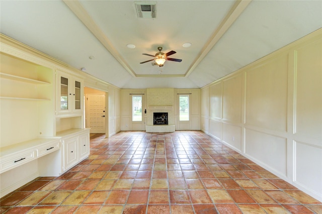 17522 Sorrel Ridge Dr, Spring, TX 77388 - unfurnished living room featuring a decorative wall, a tray ceiling, ceiling fan, and a fireplace