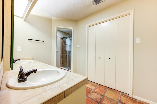 17522 Sorrel Ridge Dr, Spring, TX 77388 - full bathroom featuring tiled shower, double vanity, and a textured ceiling