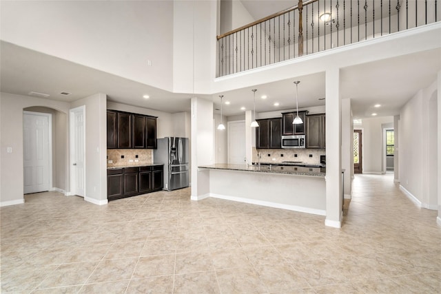 5227 Birch Falls Ln, Sugar Land, TX 77479 - unfurnished living room with light tile patterned floors, a towering ceiling, recessed lighting, and arched walkways