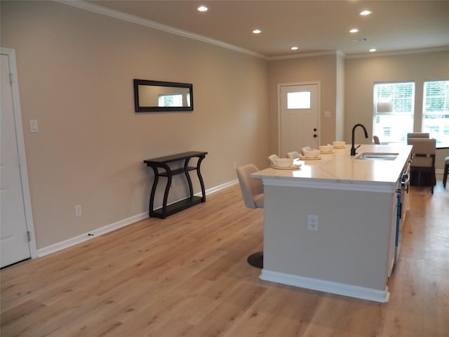 4218 Sorsby Dr, Houston, TX 77047 - kitchen featuring light wood finished floors, crown molding, recessed lighting, an island with sink, and light countertops