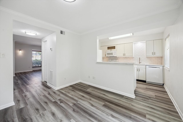 6451 Olympia Dr Unit 96, Houston, TX 77057 - kitchen with white appliances, white cabinetry, light countertops, backsplash, and wood finished floors