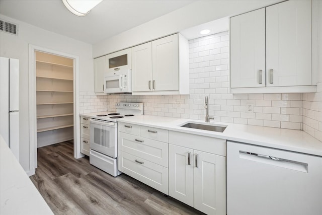 6451 Olympia Dr Unit 96, Houston, TX 77057 - kitchen featuring white appliances, light countertops, white cabinets, tasteful backsplash, and dark wood-style floors