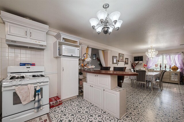530 Frankie St Unit 1, Houston, TX 77015 - kitchen featuring white appliances, a chandelier, under cabinet range hood, crown molding, and white cabinets