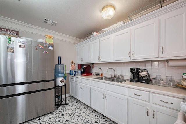 530 Frankie St Unit 1, Houston, TX 77015 - kitchen featuring freestanding refrigerator, white cabinetry, light countertops, ornamental molding, and tasteful backsplash