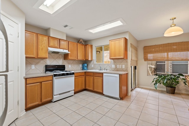 15506 Elm Leaf Pl, Cypress, TX 77429 - kitchen with white appliances, under cabinet range hood, light countertops, and tasteful backsplash