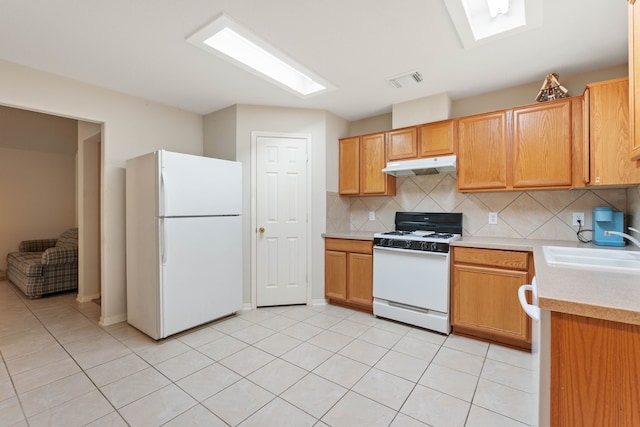 15506 Elm Leaf Pl, Cypress, TX 77429 - kitchen with white appliances, under cabinet range hood, light countertops, tasteful backsplash, and light tile patterned floors