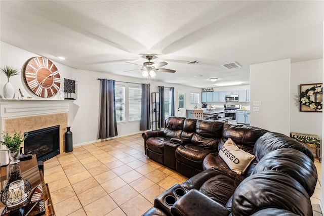 2830 Katybriar Ln, Katy, TX 77449 - living room featuring ceiling fan, light tile patterned floors, and a glass covered fireplace