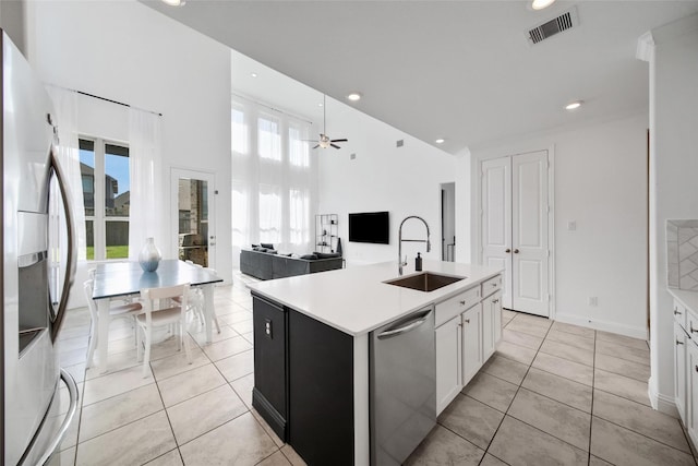 3310 Bellwick Chase Ln, Houston, TX 77365 - kitchen featuring appliances with stainless steel finishes, a high ceiling, light countertops, white cabinets, and an island with sink