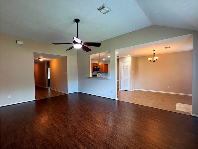 13693 Bighorn Trl, Willis, TX 77378 - unfurnished living room with wood finished floors, a chandelier, a ceiling fan, and lofted ceiling