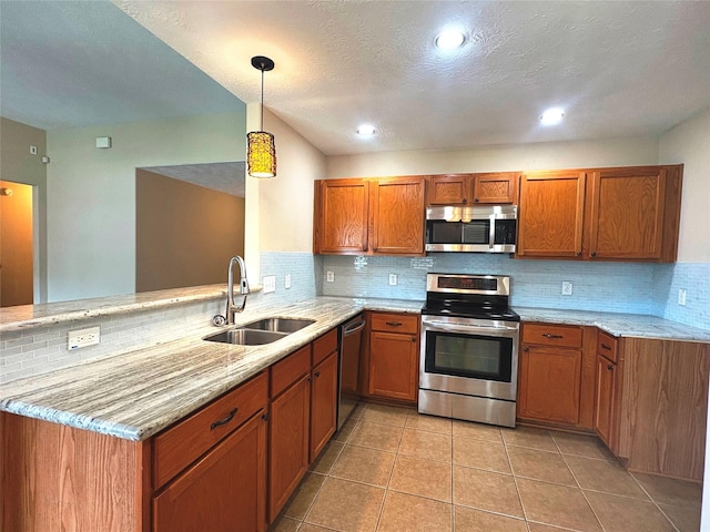 13693 Bighorn Trl, Willis, TX 77378 - kitchen with stainless steel appliances, brown cabinets, backsplash, light stone counters, and recessed lighting