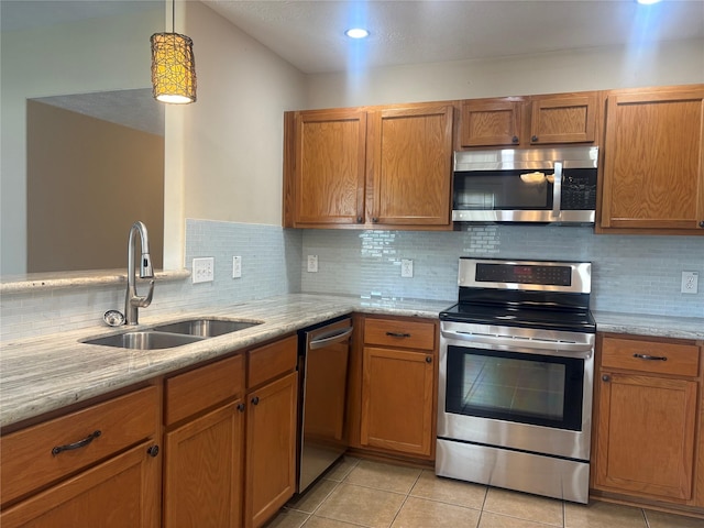 13693 Bighorn Trl, Willis, TX 77378 - kitchen with stainless steel appliances, brown cabinetry, decorative backsplash, light stone counters, and vaulted ceiling