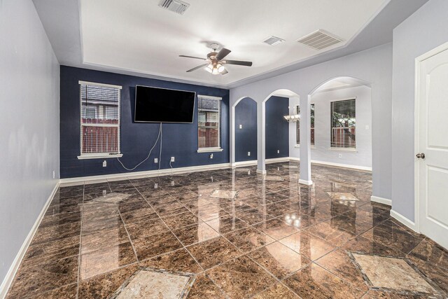 12222 Warrenwood Dr, Houston, TX 77066 - empty room featuring arched walkways, plenty of natural light, and a ceiling fan