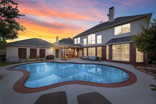 16047 Lockdale Ln, Cypress, TX 77429 - rear view of property featuring outdoor lounge area, an outdoor pool, a chimney, a patio, and brick siding