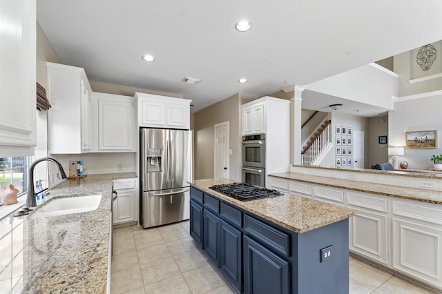 16047 Lockdale Ln, Cypress, TX 77429 - kitchen with stainless steel appliances, blue cabinets, white cabinets, a center island, and recessed lighting