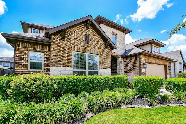 14618 Moccasin Ridge Dr, Cypress, TX 77433 - view of front facade with brick siding, stone siding, a garage, and roof with shingles