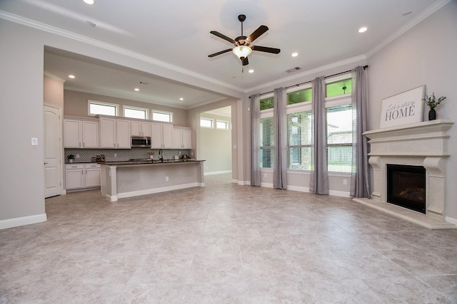 14618 Moccasin Ridge Dr, Cypress, TX 77433 - kitchen with stainless steel microwave, open floor plan, dark countertops, crown molding, and ceiling fan