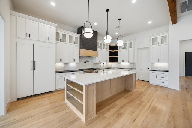 1419 Candlelight Ln, Houston, TX 77018 - kitchen featuring open shelves, decorative backsplash, a kitchen island with sink, light wood-type flooring, and recessed lighting