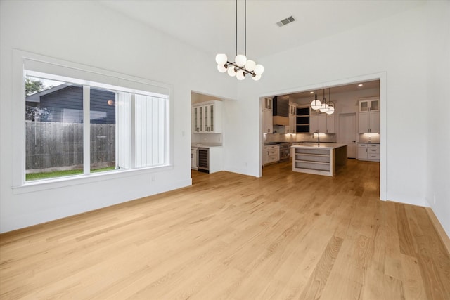 1419 Candlelight Ln, Houston, TX 77018 - unfurnished living room featuring a chandelier, light wood-type flooring, and wine cooler